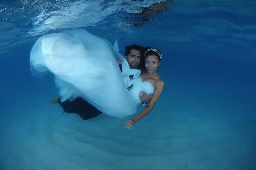 Junges Ehepaar in Hochzeitskleidung unter Wasser - Heiraten im Ausland
