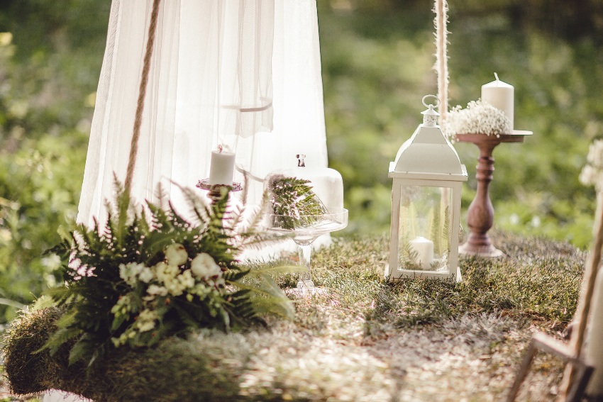 Brautkleid auf der Wiese mit Kerzen