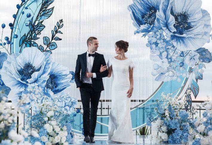 Brautpaar vor Blumenkulisse - Wie viel kostet eine Hochzeit