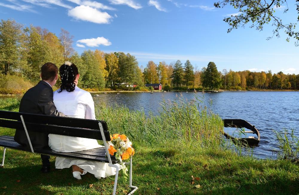 Brautpaar sitz auf einer Bank am See