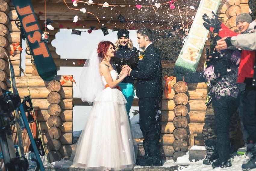 Hochzeitspaar vor einer Skihütte - Hochzeit im Schnee