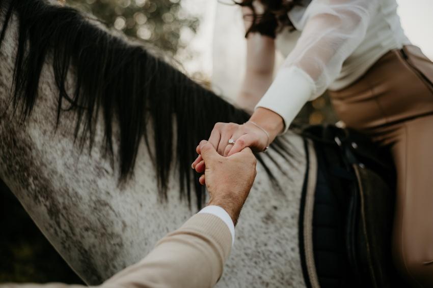 Junge Frau auf Pferd zeigt Verlobungsring - Heiratsantrag mit Pferd