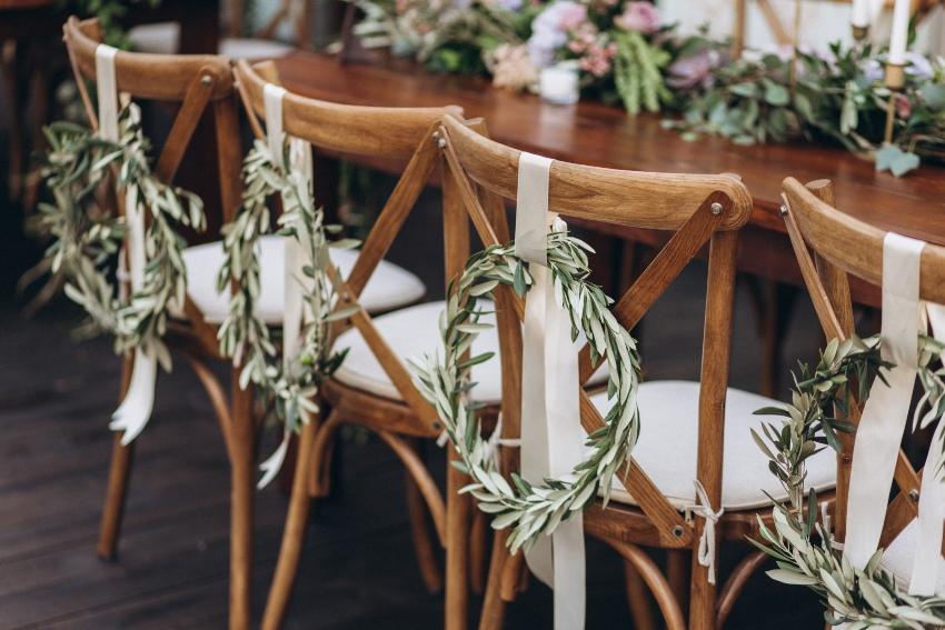 Kränze aus Pflanzen an Stühlen für eine Hochzeitsdekoration