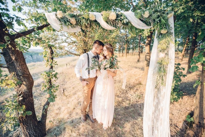 Brautpaar steht unter Bäumen - Greenery Hochzeit