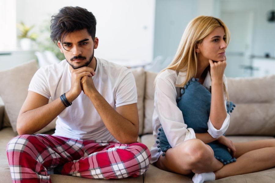 Junges Paar unglücklich auf einer Couch - Verlobung aufgelöst