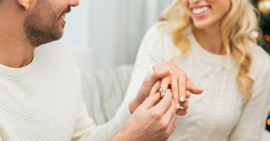 Mann legt Frau Verlobungsring an - Lebenslange Garantie auf Verlobungsringe