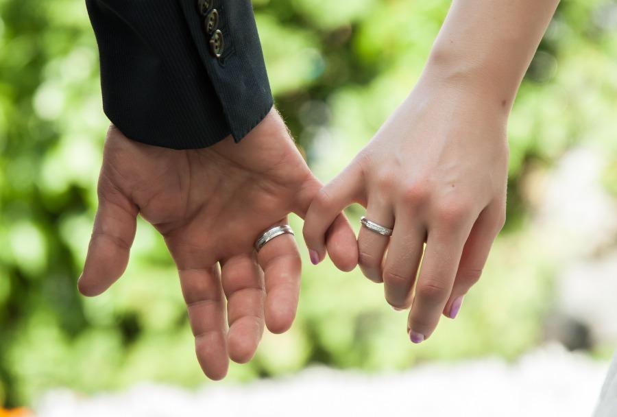 Nachaufnahme, Hände eines verheirateten Paares mit Eheringen - Wie viel Trauringe kosten sollten