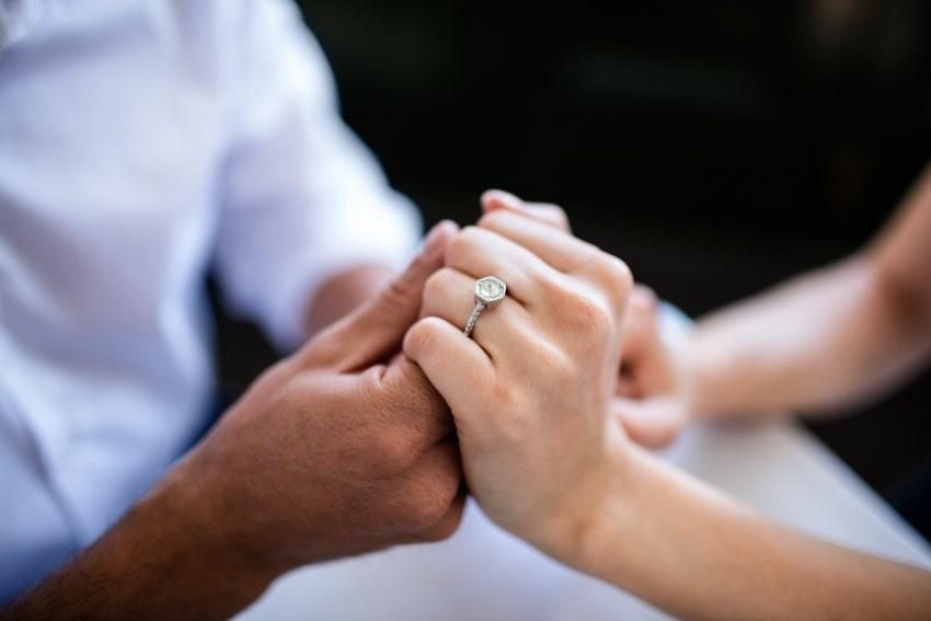 Verlobtes Paar, Nahaufnahme der Hände, Verlobungsring an der Hand der Frau - Verlobungsring-Design nach Wunsch
