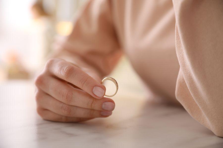 Frau hält einen Ehering in ihrer Hand