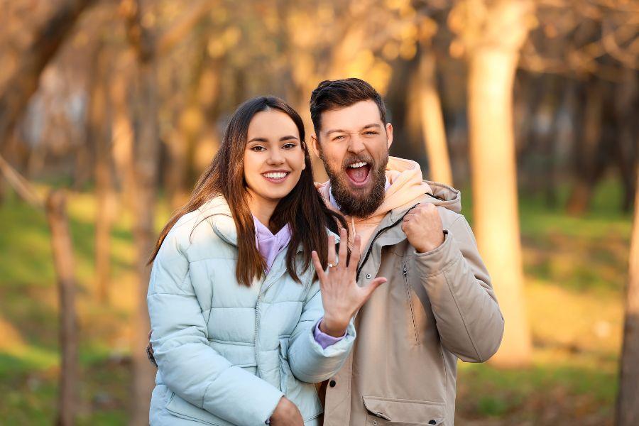 Junges Paar hat sich verlobt, Frau zeigt Verlobungsring