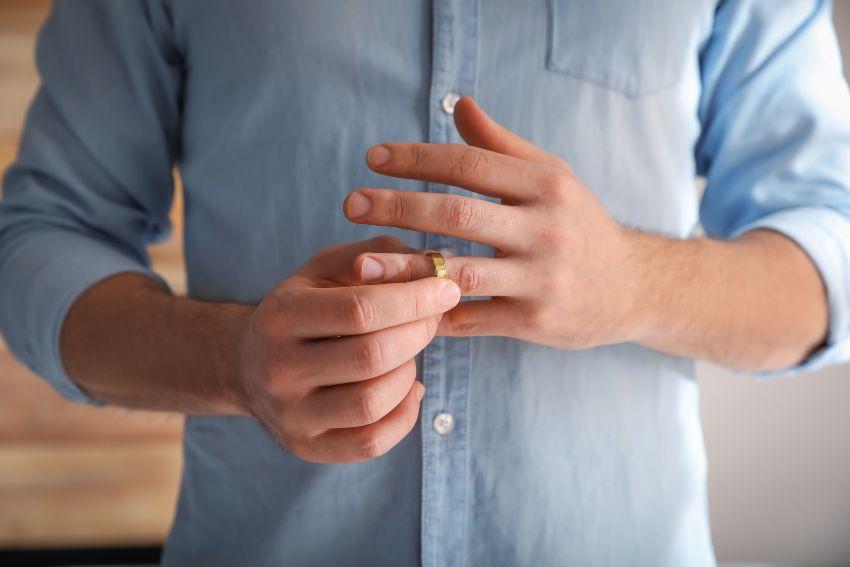 Mann nimmt Ehering vom Finger - Was tun mit Ehering nach der Scheidung?