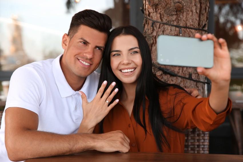 Junges Paar macht Selfie nach Verlobung